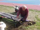 Agostino Crociani al lavoro per rimettere a posto la panchina rotta dai vandali