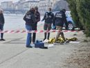 cadavere con forze di polizia intorno