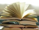 libro aperto su altri libri