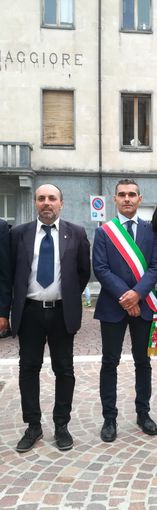 Due persone in piedi, una con fascia tricolore