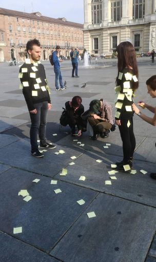 Due ragazzi ricoperti da post it in mezzo a piazza Castello