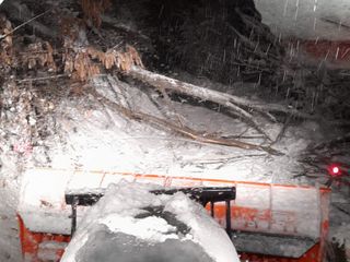 Un trattore spalaneve bloccato da un albero
