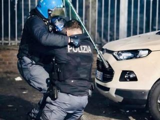 L'agente soccorso da un  collega dopo essere stato accerchiato e picchiato [Foto dal profilo social di Alberto Cirio]