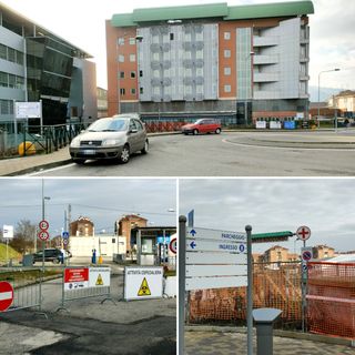 Le auto parcheggiate davanti alla rotatoria ed il parcheggio occupato dalle tende militari