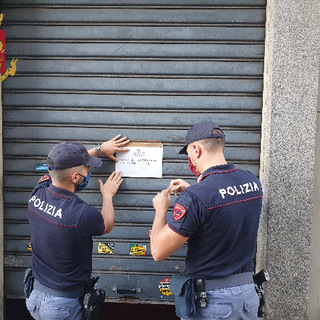 Poliziotti mettono cartello di chiusura imposta per un locale bar