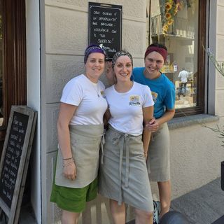 Commercianti cavouresi sotto una lavagnetta con frase motivante