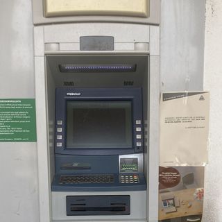 Il bancomat con il foglio che annuncia la chiusura