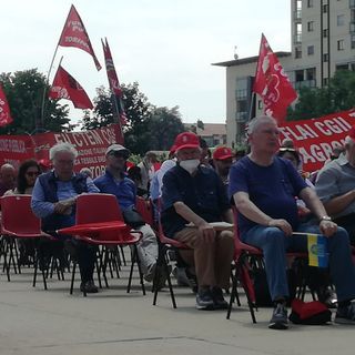 persone sedute con bandiere Cgil