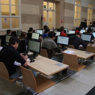 Studenti davanti ai computer tra i banchi di scuola