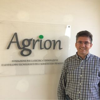 Uomo sorridente davanti a una parete