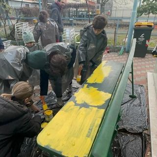 bambini che colorano una panchina di giallo
