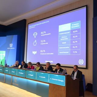 convegno in una sala con palco rialzato e schermi illuminati