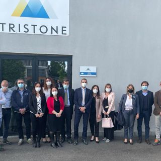 Delegazione in visita di fronte a un'azienda