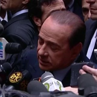 Silvio Berlusconi circondato dai microfoni