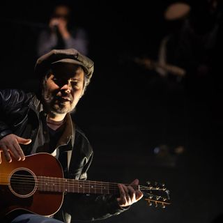 artista sul palco con una chitarra