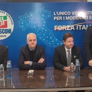 Persone davanti a simboli elettorali