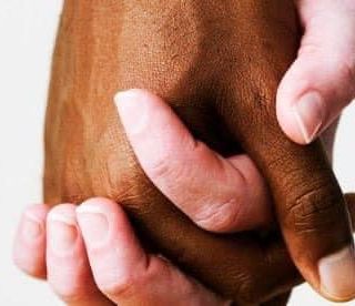 mani di due colori diversi che si stringono