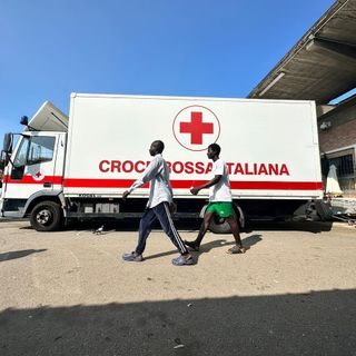 Bus della Croce Rossa e due migranti