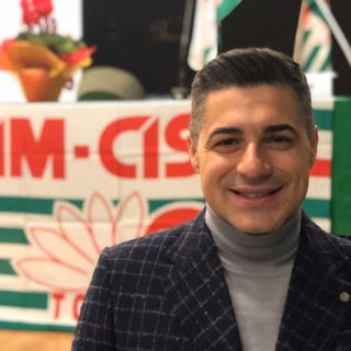 Davide Provenzano davanti a una bandiera della Fim