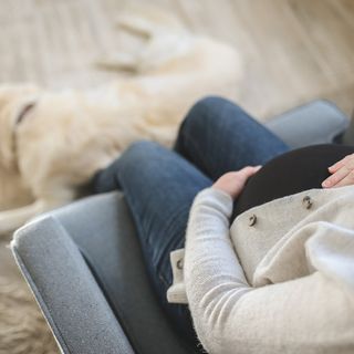 Donna incinta seduta su un divano