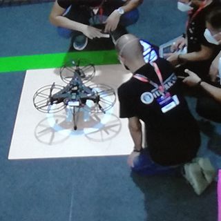 persone inginocchiate intorno a un drone
