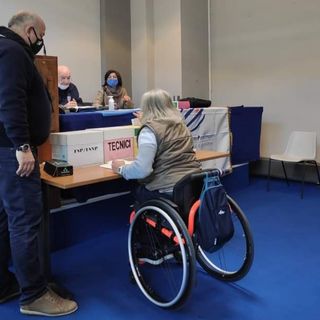 Persona su una sedia a rotelle che vota