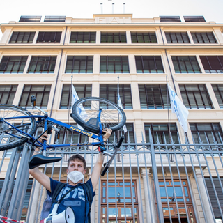 ragazzo che solleva una bicicletta davanti a ex sede Fiat