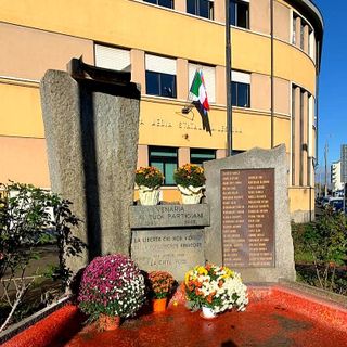 fiori ai piedi di un monumento dedicato ai partigiani