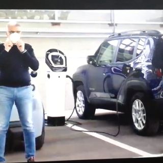due uomini davanti a due auto elettriche