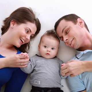 mamma, papà e un bimbo in mezzo a loro