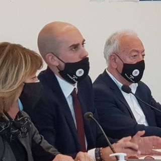 tre persone sedute a un tavolo