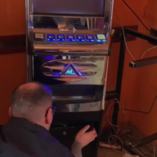 uomo della guardia di finanza con slot machine