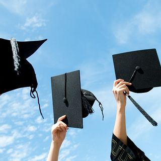 laureati che lanciano il cappello in aria