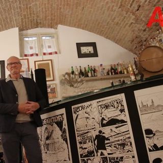 Luigi Piccatto appoggiato a un bancone con tavole disegnate