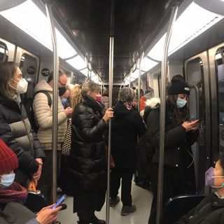 Persone in metropolitana con mascherine