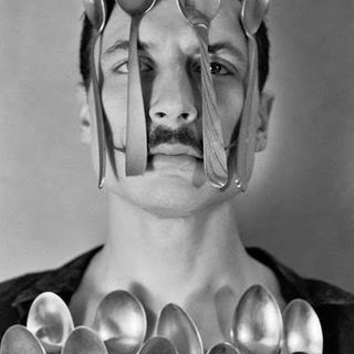 Artista che compie un numero con alcuni cucchiai