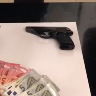 Soldi e una pistola su un tavolo dei carabinieri