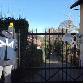 Agente Dia davanti a un cancello di una villa