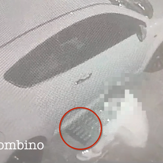 Uomo che preleva un tombino da sotto un'auto parcheggiata
