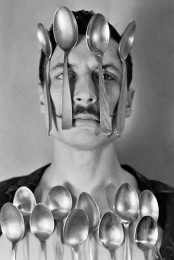 Artista che compie un numero con alcuni cucchiai