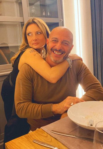 uomo che sorride abbracciato da una donna uomo che sorride abbracciato da una donna