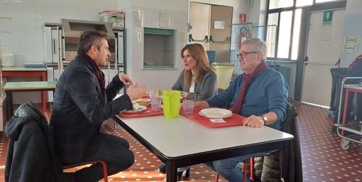 tre persone sedute a un tavolo