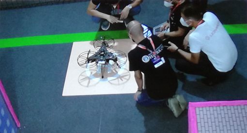 persone inginocchiate intorno a un drone persone inginocchiate intorno a un drone