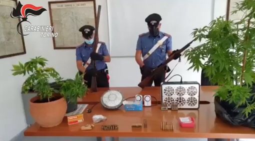 carabinieri di fronte a un tavolo con cose sequestrate