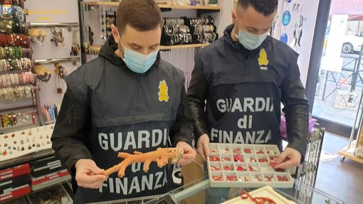 Uomini della Guardia di Finanza con prodotti sequestrati in mano