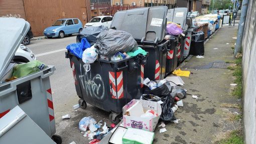 Bidoni strapieni e immondizia dappertutto in via Torricelli a Nichelino