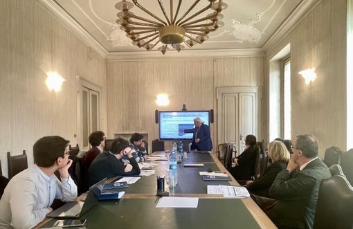 Presentazione di statistiche davanti a una tavolata Presentazione di statistiche davanti a una tavolata