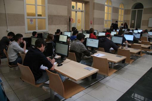 Studenti davanti ai computer tra i banchi di scuola