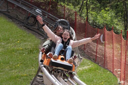 Alpine coaster con persone sedute sopra Alpine coaster con persone sedute sopra