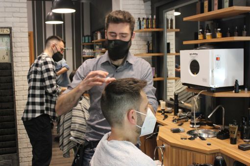 Barbiere al lavoro con un cliente Barbiere al lavoro con un cliente